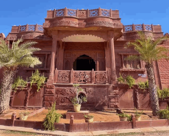 Royal red sandstone heritage pavilion at Camp Thar Osian with intricate carved stone jharokhas